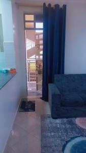 a living room with a blue couch and a mirror at Panorama bnbs meru in Meru