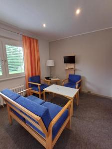 a room with two beds and a table and chairs at Hotel am Lärchenberg in Schirgiswalde