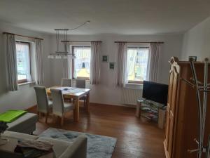 a living room with a table and a dining room at Ruhlander-Hof in Unterwössen