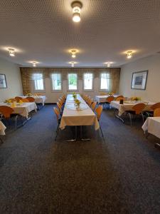 a banquet hall with tables and chairs in a room at Hotel am Lärchenberg in Schirgiswalde