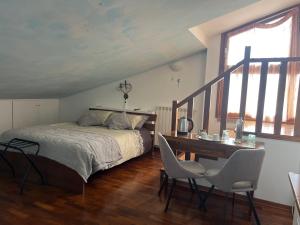a bedroom with a bed and a desk with chairs at B&B Menta e Rosmarino in Chiassa Superiore