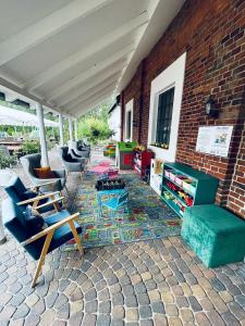 a patio with couches and chairs on a brick wall at KARCZMA-KOSZWICE in Koszwice