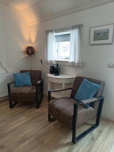 a living room with a couch and a chair at Bed And Breakfast Geertruidahoeve in Hellendoorn