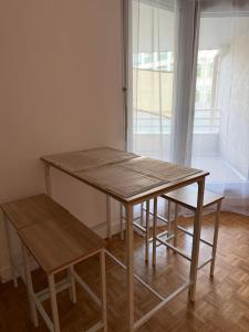 a wooden table and bench in a room with a window at appartement cosy Paris 17eme in Paris +6 photos