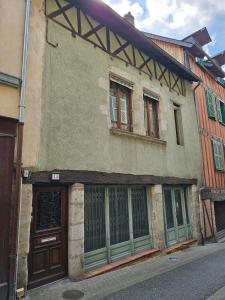 an old building with green doors and windows on a street at Maison de ville duplex TULLE in Tulle