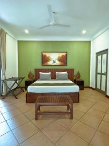 a bedroom with a large bed and a table at The Villa Green Inn in Negombo