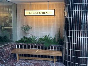 a sign on the side of a store with a bench at Silom Serene A Boutique Hotel in Bangkok