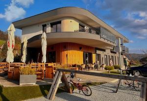 a house with a bike parked in front of it at Romantic Sunset Retread I 4 Min to A2 I E-Bikes I Near Ljubljana in Velika Loka