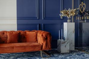 a couch in a blue room with a blue wall at Grădina Mariajelor Hotel in Câmpulung Moldovenesc
