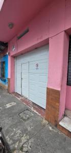 a pink building with two garage doors on it at Private Apt, AC, Jacuzzi, parking Centro in Escuintla