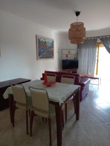 a dining room table and chairs in a living room at Vilamoura Seaside Serenity T3 AP - Pool, BBQ, 3min Walk to Beach in Quarteira