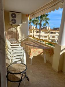 a balcony with chairs and a table and a table at Vilamoura Seaside Serenity T3 AP - Pool, BBQ, 3min Walk to Beach in Quarteira