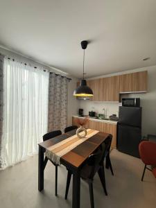 a kitchen with a wooden table and a black refrigerator at Casa Joseph in Aga +8 photos