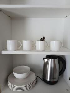 a shelf with cups and plates and a tea kettle at Casa Joseph in Aga