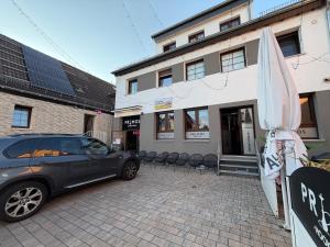 a car parked in front of a building with an umbrella at Pension Raunheim in Raunheim