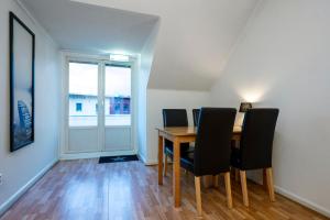a dining room with a table and chairs and a window at Port Hotel Apartments in Karlshamn