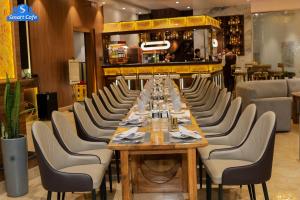 a dining room with a long table and chairs at Hotel Smart Durbar in Dharampur
