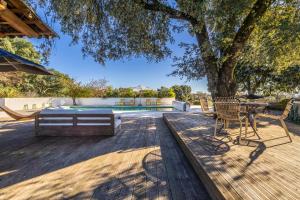 a wooden deck with a table and chairs next to a tree at Casinha Revira Volta in Nesperal