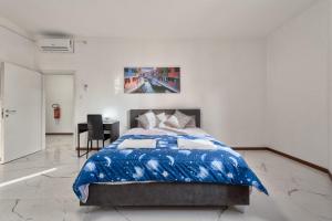 a bedroom with a blue comforter on a bed at Cesare Room in Apartment in Marghera