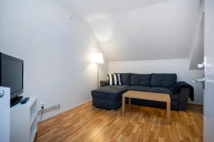 a living room with a blue couch and a table at Port Hotel Apartments in Karlshamn