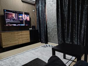 a living room with a flat screen tv and curtains at Apartament Maya luxury in Bucharest