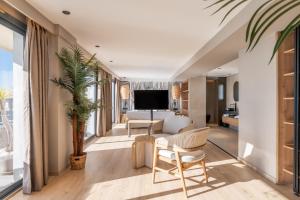a living room with a couch and a tv at Marins Suites - Adults Only Hotel in Cala Millor
