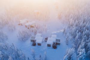an aerial view of snow covered houses in a forest at Northern Lights Ranch in Levi +64 photos