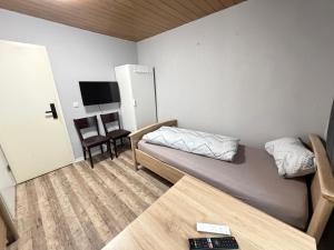 a small room with a bed and a table at Pension Raunheim in Raunheim