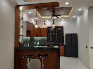 a kitchen with a black counter and a refrigerator at Villa KARISMA Candidasa in Candidasa
