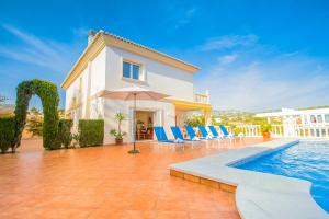 a villa with a swimming pool and blue chairs at Villa La Marina by Abahana Villas in Benissa