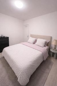 a white bedroom with a large bed with white sheets and pillows at Casaejon in Lelystad