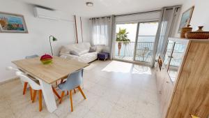 a living room with a table and a couch at Apto Mar Blau in L'Ampolla