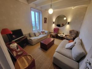 a living room with a couch and a table at La bien-aîmée in Ploubazlanec