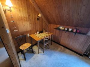 a wooden table and chairs in a room with wooden walls at La bien-aîmée in Ploubazlanec