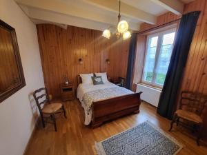 a bedroom with a bed and a window at La bien-aîmée in Ploubazlanec