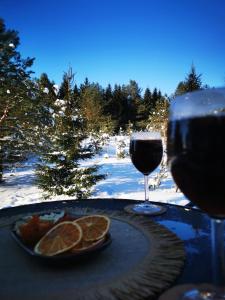 a table with a plate of food and a glass of wine at Skubėk Neskubėti in Klykiai