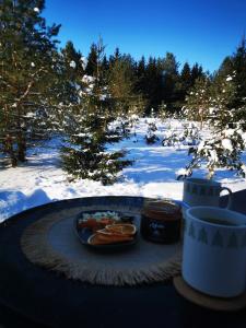 a plate of food on a table in the snow at Skubėk Neskubėti in Klykiai