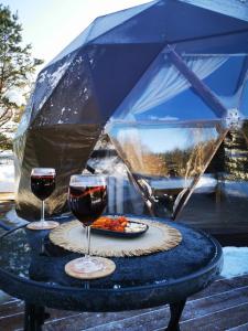 a table with two glasses of wine and a plate of food at Skubėk Neskubėti in Klykiai