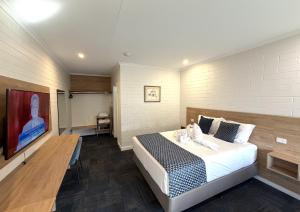 a bedroom with a bed in a room with a wall at Katherine Motel in Katherine