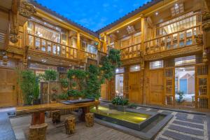 a large wooden building with a pond in the middle at Sunlit Snow Mountain Z Naxi Ethnic Style Courtyard in Lijiang