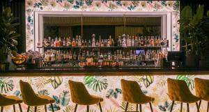 a bar with yellow chairs in front of it at Dorsett Shepherds Bush London in London