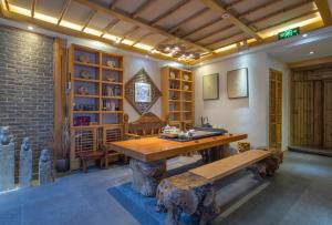 a room with a wooden table and a bench at Sunlit Snow Mountain Z Naxi Ethnic Style Courtyard in Lijiang
