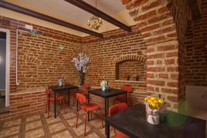 a room with two tables and chairs and a brick wall at Maison BERTHELOT in Bucharest