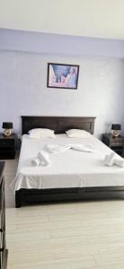 a bedroom with a bed with white sheets and pillows at Naparis Boutique in Eforie Sud +24 photos