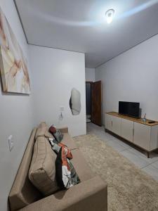 a living room with a couch and a tv at Apartamento completo - a 3 minutos do centro in Alta Floresta