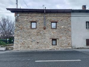 a stone building on the side of a street at Affittacamere il Gallo Panoramico - Alpine Trekking Stay in Donato
