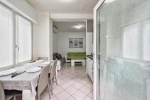a dining room with a table and a glass door at Marila 5, a due Passi dal Mare in Lido di Jesolo +12 photos