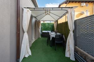 a patio with a table and chairs under a tent at Marila 5, a due Passi dal Mare in Lido di Jesolo