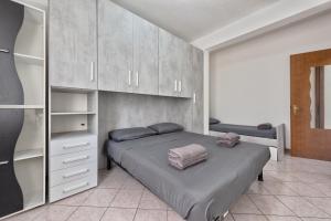 a bedroom with a bed and some cabinets at Marila 5, a due Passi dal Mare in Lido di Jesolo