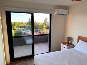 a bedroom with a bed and a large sliding glass door at Carmelo Postal in Carmelo